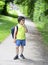 Kid with standing alone and puting finger on his mouth with bored face, Unhappy kid get bored waiting for school bus, School boy c