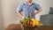 Kid stands in front of a basket of fruits and vegetables on a wooden table