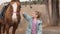 kid stroking a beautiful brown harnessed horse with a white spot