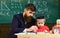 Kid studies individually with teacher, at home. Individual schooling concept. Teacher and pupil in mortarboard