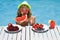 Kid on summer vacation. Child in swimming pool with summer fruits. Kids summer vacation. Beach and sea water fun. Summer