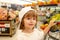 Kid in supermarket shop. Toddler boy with shopping bag in store.