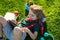 Kid with tablet device sitting outdoor in garden, wearing short and stripy shirt. Child outdoor school, education, on