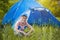 Kid with a tent on a camomile meadow