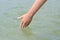 Kid touching cool clear water outdoors, closeup