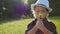 Kid tourist examines flower with a magnifying glass in the park. Travel tourism adventure concept. Little kid boyscout