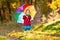 Kid with umbrella playing in autumn rain