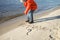 Kid walking at the beach in winter, cold temperature and sunny day, love keep you warm