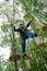 Kid walking on a logs path in adventure park