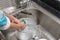 Kid washing dishware in the kitchen sink