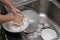 Kid washing dishware in the kitchen sink