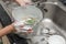 Kid washing dishware in the kitchen sink