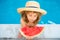 Kid with watermelon smiling swimming in pool on summer on resort. Children with piece of water melon outdoor. Summer