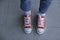 Kid wearing different pair of socks. Child legs in mismatched socks on gray background. Odd Socks day, Anti-Bullying