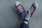 Kid wearing different pair of socks. Child legs up in mismatched socks on gray background. Odd Socks day, Anti-Bullying