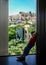 Kid at the window, gazing the view to Acropolis and Parthenon temple in Athens city, Greece