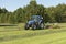 The kidding of shaken grass with blue tractor with