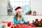 Kids bake Christmas cookies. Child in Santa hat cooking, decorating gingerbread man for Xmas celebration. Family preparing sweets