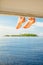 Kids bare feet over boat decking with small island and blue sea as a background. . Vacation holidays concept