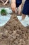 Kids building sand castle with wet sand - childrens hands, feet