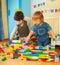 Kids building a wall of plastic blocks