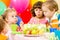 Kids celebrate birthday blowing candles on cake