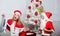 Kids celebrate christmas with gifts. Boy kid santa with white artificial beard and red hat give bag to girl. Santa bring