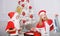 Kids celebrate christmas with gifts. Boy kid santa with white artificial beard and red hat give bag to girl. Santa bring