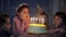 Kids celebrating birthday party and blowing candles on cake