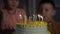 Kids celebrating birthday party and blowing candles on cake