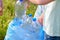 Kids cleaning in park.Volunteer children with a garbage bag cleaning up litter, putting plastic bottle in recycling bag.