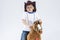 Kids Consepts. Portrait of Caucasian Little Boy in Cowboy Clothing Making Fases Posing With Symbolic Plush Horse Against White.