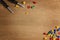 Kids construction toys tools: colorful screwdrivers, screws and nuts on wooden background. Top view. Copy space for text