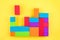 Kids designer of multi-colored volumetric 3d geometric shapes on yellow background. Logical educational game