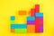 Kids designer of multi-colored volumetric 3d geometric shapes on yellow background. Logical educational game.