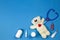 Kids doctor concept. Teddy bear, stethoscope, medical toy kit and medications on blue background. Top view