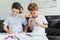 kids drawing pictures with colorful pencils while father resting on sofa