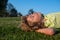 Kids dreaming. Kid playing in the meadow. Happy healthy caucasian child boy with lying on the grass field background