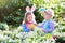 Kids on Easter egg hunt in blooming spring garden