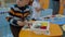 Kids and educator playing with plastic building blocks at kindergarten