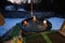 Kids enjoying bathing in wooden barrel hot tub in the terrace of the cottage. Scandinavian bathtub with a fireplace to burn wood