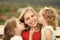 Kids enyoj happy day. Woman and girls sit on bench