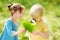 Kids exploring nature with magnifying glass. Close-up. Little boy and girl looking on leaf with magnifier