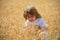 Kids farmer on field. Wheat is a cereal plant, the grain of which is ground to make flour. Small boy child enjoy