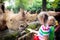 Kids feed rhino in zoo. Family at animal park