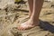 Kids feet in wet sand, mud. Barefeet child playing with wet sand on summer sunny day