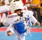 Kids fighting on stage during Taekwondo contest