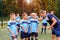 Kids in football uniform listening to explain of coach before match.