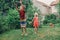 Kids friends boy and girl splashing with gardening hose on backyard on summer day. Children playing with water outdoor at home