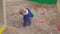Kids Games. Baby boy digging in the sandbox. Smiles and touches the sand.